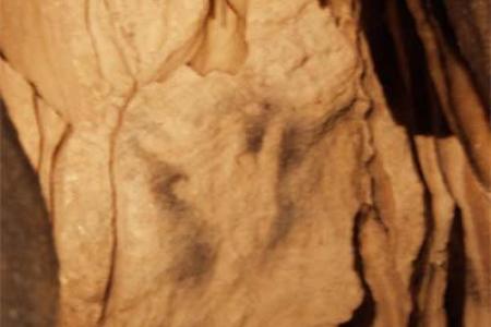 Grabado de una mano en una cueva rupestre.